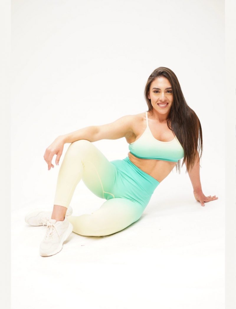 Gera, founder of CoraZONE Fitness, seated in mint activewear, inviting the community to connect and grow.