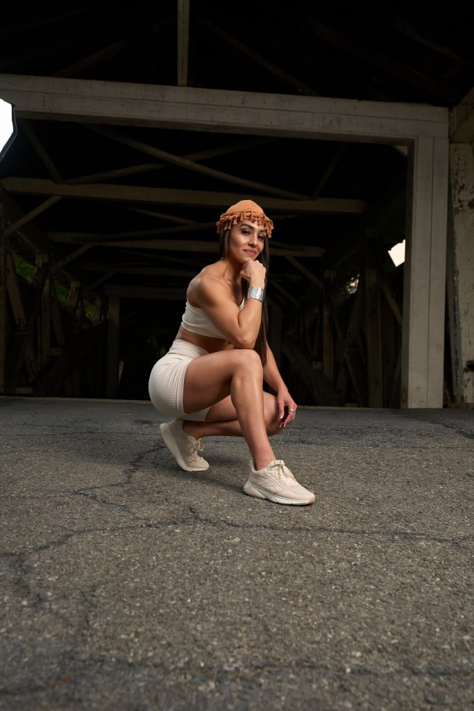 Gera crouching in athletic wear, exuding strength and confidence — empowering women to build physical and mental resilience.